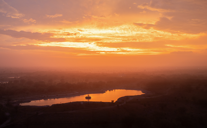 Sunset over the restored lake at Dhun with haze across the plain